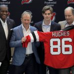 New Jersey Devils forward Jack Hughes, center right, the No. 1 overall pick in the 2019 NHL draft, poses for photographers with former NHL player Kevin Weekes, far left, Josh Harris, second from left, managing partner of Harris Blitzer Sports & Entertainment, and Ray Shero, Devils executive vice president and general manager, during a news conference introducing the prospect to local media, Tuesday, June 25, 2019, in Newark, N.J.